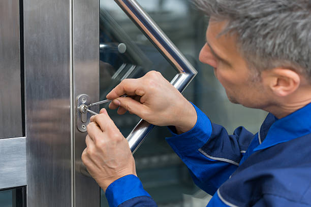 Reifer männlicher Schlüsseldienst, der den Türgriff zu Hause befestigt